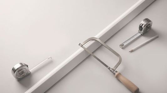 Illustration of PVC profile being cut with a fine-toothed saw, with tape measures and pencil alongside